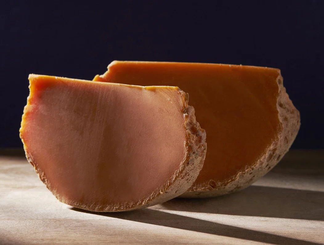 Flattened top and bottom, and about the size of a small bowling ball, it begins its life as Mimolette Jeune. After maturation the centre acquires a perfumed yet salty flavour and graduates to be called Mimolette Vieille.