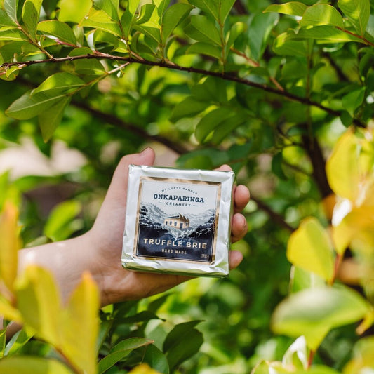 A modest amount of black truffle is mixed through the curd to create a gentle truffle flavour and aroma that blends seamlessly with the cheese without overpowering it. The interior is a creamy ivory dotted with small black flecks of truffle.