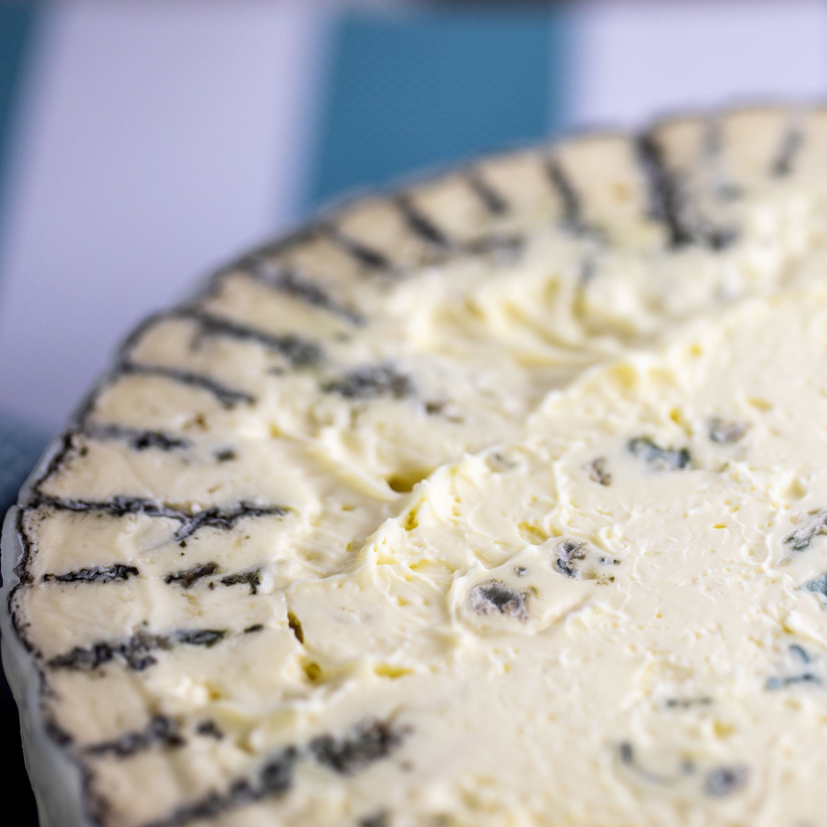 Close-up of a blue cheese wheel with a blurred background. Tarago River Shadows of Blue