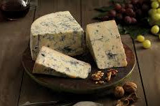 Gorgonzola Piccante - Blue cheese on a wooden board with grapes and nuts